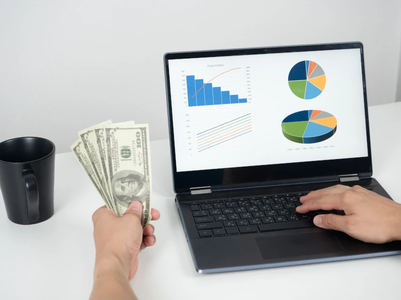 vecteezy man hand holding money dollar and using laptop on the table 16684753